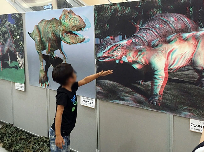 「大きく飛び出すよ！」飛び出す３Ｄ恐竜ポスターを楽しむ男の子。