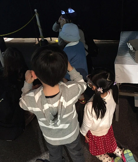 飛び出す３Ｄ恐竜展（映像版）を楽しむお子様。