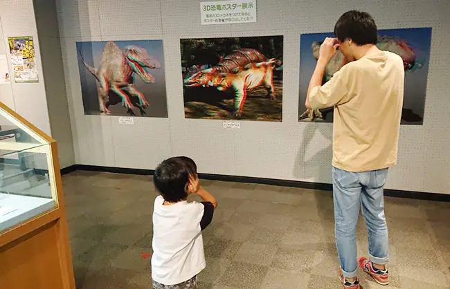 『パパ、恐竜が飛び出してきた！』と驚く親子の表情が印象的です。