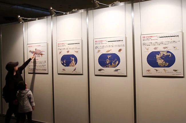 恐竜パネルで学ぶ親子。