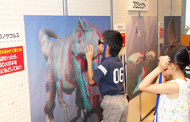 飛び出す3Ｄ恐竜展ポスターに夢中の子どもたち