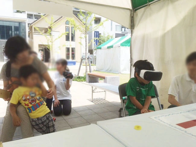 360度ブイアール映像「ティラノサウルスに遭遇！」を体験するお子さん。目の前に現れる数々の古生物にびっくり。