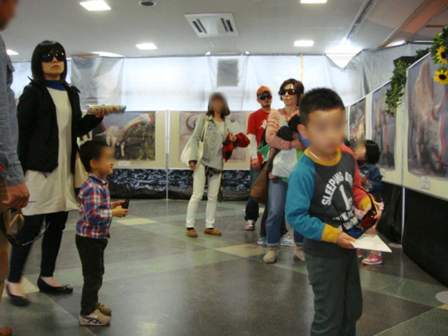 飛び出す３Ｄ恐竜展ポスター展示に夢中の男の子