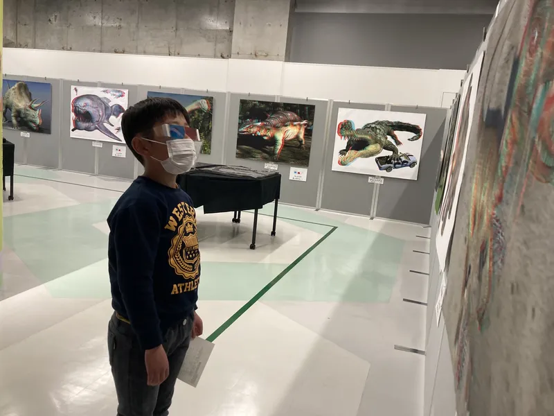 目の前に恐竜が飛び出してくる「飛び出す３Ｄ恐竜ポスター展示」。※お子さんの目には恐竜が飛び出して見えています。