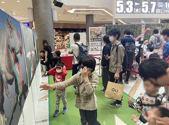 「わー本当に飛び出てる！」３D恐竜ポスターに思わず手を伸ばす男の子。