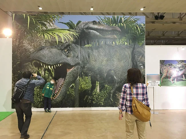 実寸大のティラノサウルスが描かれた巨大な垂れ幕の前は写真撮影スポットに。